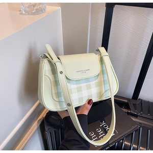 Dettaglio del motivo vichy verde chiaro e del logo sulla borsa a tracolla in pelle