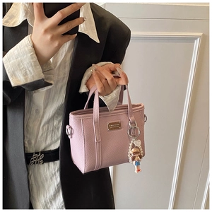 Mini borsa tote lavanda con trama litchi e ciondolo di perle mostrata in un selfie