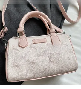 Detail of deer print and dot patterns on pink and cream textured boston handbag