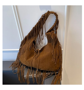 Detailed view of the brown suede tote bag featuring long decorative fringe and soft texture