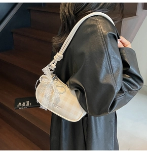 Détail du sac damier avec nœud en dentelle, breloque perle et bandoulière à nœuds