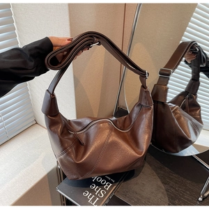 Macro shot of dark brown glossy leather texture with contrast stitching and silver zipper