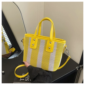 Détail du sac seau tissé jaune et blanc avec poignée en cuir et bandoulière amovible