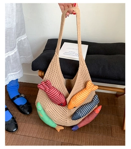 Detail of beige knit tote bag with colorful stuffed fish charms and mesh texture