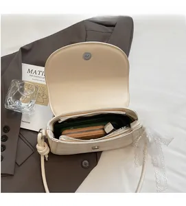 Interior view of off-white saddle bag showing capacity for phone, wallet and cosmetics