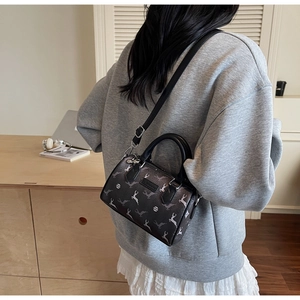 Detailed view of the crossbody Boston bag with deer prints shown on a model