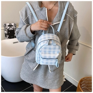 Gros plan d'un mini sac à dos à carreaux bleu clair avec détails de fermeture éclair