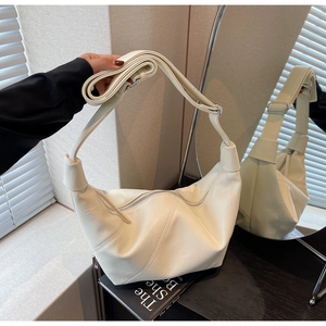 Detail of minimalist beige hobo bag with adjustable strap and textured faux leather finish