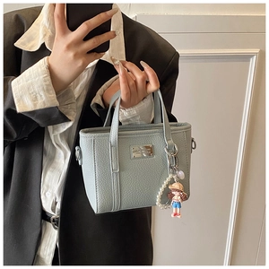 Detailansicht der hellblauen Eimertasche mit Litschi-Muster und Perlenanhänger