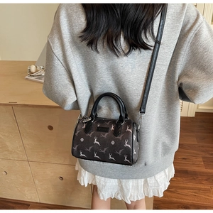Fashionable grey Boston bag with white deer print shown on model in a cozy indoor setting