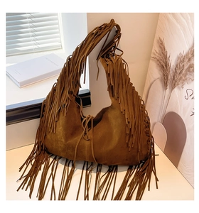 Close-up of brown suede hobo bag with long tassels and retro bohemian style detail
