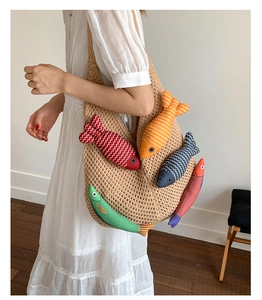 Close-up of handmade knit tote bag featuring colorful 3D fish charms and woven texture