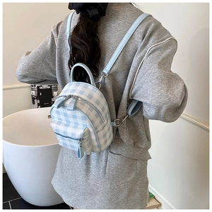 Vue détaillée du mini sac à dos avec motif à carreaux bleus et blancs et bretelles réglables