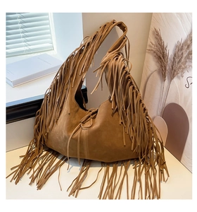 Detailed view of the brown suede tote bag featuring long fringes and bohemian style