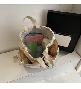 Spacious interior of beige drawstring backpack showing laptop and daily essentials storage