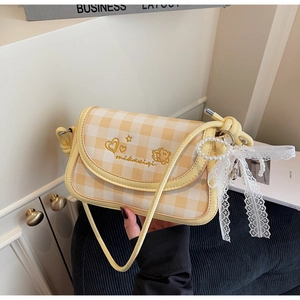 Detail of yellow plaid crossbody bag featuring cute heart embroidery and pearl bow charm
