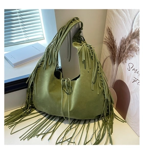 Detail of matcha green suede tote bag showing long tassels and soft matte texture