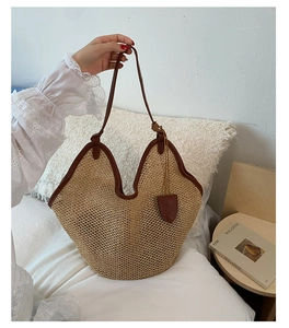 Close-up of woven straw beach bag with brown leather trim and wavy edge detail