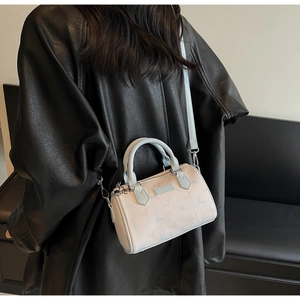 Detailed back view of off-white Boston bag with blue animal prints and leather strap