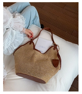 Macro shot of large woven straw tote bag with brown leather handles and inner storage