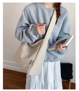 Detail of a minimalist off-white canvas bag featuring a black FASHION side label