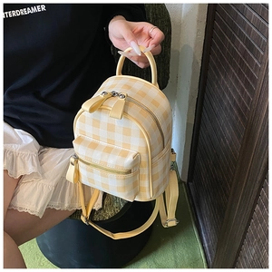 Détail d'un mini sac à dos à carreaux jaunes et blancs avec tirette nœud papillon