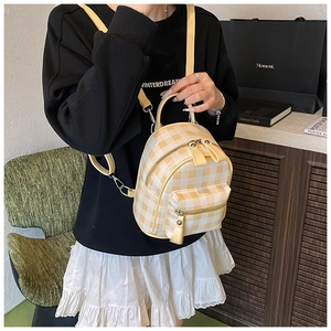Detail of yellow gingham mini backpack featuring a zipper pocket and versatile straps