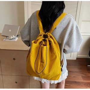 Close-up of bright yellow lightweight nylon backpack with black drawstring closure