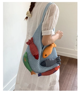 Close-up of handmade knit tote bag with five colorful 3D fish charms for summer beach style