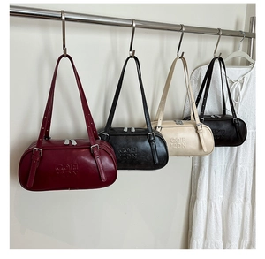 Various colors of large PU leather underarm pillow bags hanging on display hooks