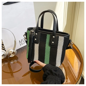 Détail du sac bandoulière en maille tissée à rayures vertes et poignées en cuir