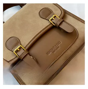 Close-up of retro brown contrast stitching bag with golden hardware and embossed logo