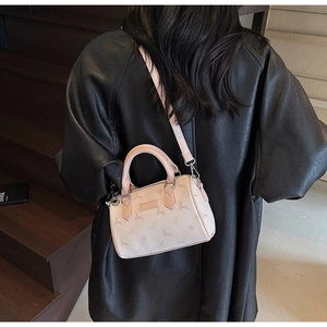 Detail of a chic pink Boston bag with deer prints worn over a black leather coat