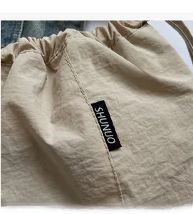 Detailed view of beige Oxford fabric drawstring bag with precise stitching and logo label