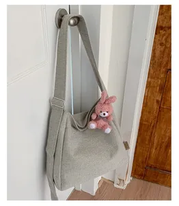 Detail of light gray canvas tote bag texture with pink plush bunny charm on white door
