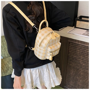 Vue de dos d'un mannequin portant le mini sac à dos à carreaux jaunes et blancs