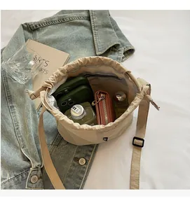 Interior view showing large capacity of the beige drawstring bucket bag with essentials