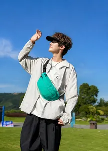 Outdoor shot of bright green nylon crossbody chest bag with adjustable black strap detail