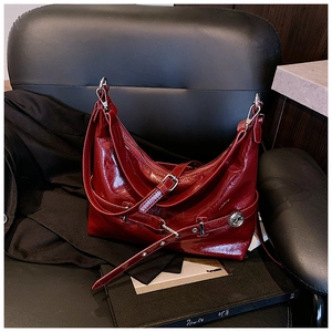 Detailed close-up of dark red crinkle patent leather texture and Z logo on underarm bag