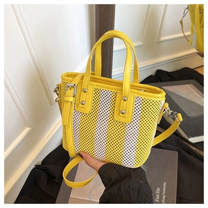 Détail du sac seau en maille tissée jaune avec finitions argentées et bandoulière