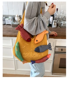 Detail of yellow knit tote bag featuring colorful plush fish charms for casual summer style