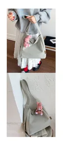 Close-up of light grey canvas tote bag featuring a cute pink plush bunny keychain charm