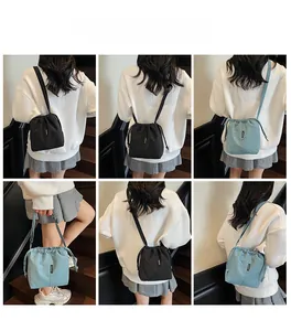 Detail view of large capacity drawstring bucket bag in black and light blue colors