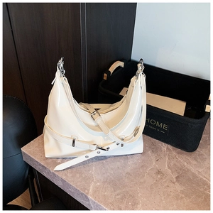 Detail of white crescent hobo bag in glossy patent leather with silver metal buckles