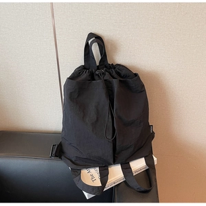 Detail of black drawstring backpack with nylon texture on black leather background