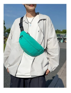 Outdoor shot showing details of mint green nylon waist bag with black adjustable strap