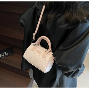 Light pink mini Boston bag with deer prints shown on a black leather jacket