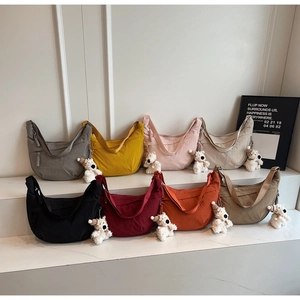 Array of nylon crescent dumpling bags in eight colors with cute plush puppy charms