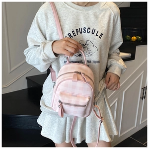 Detail of pink plaid mini backpack on model showing rabbit ears and checkerboard pattern