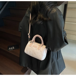 Mini Boston bag with deer pattern, pink and beige contrast, shown as a crossbody on model